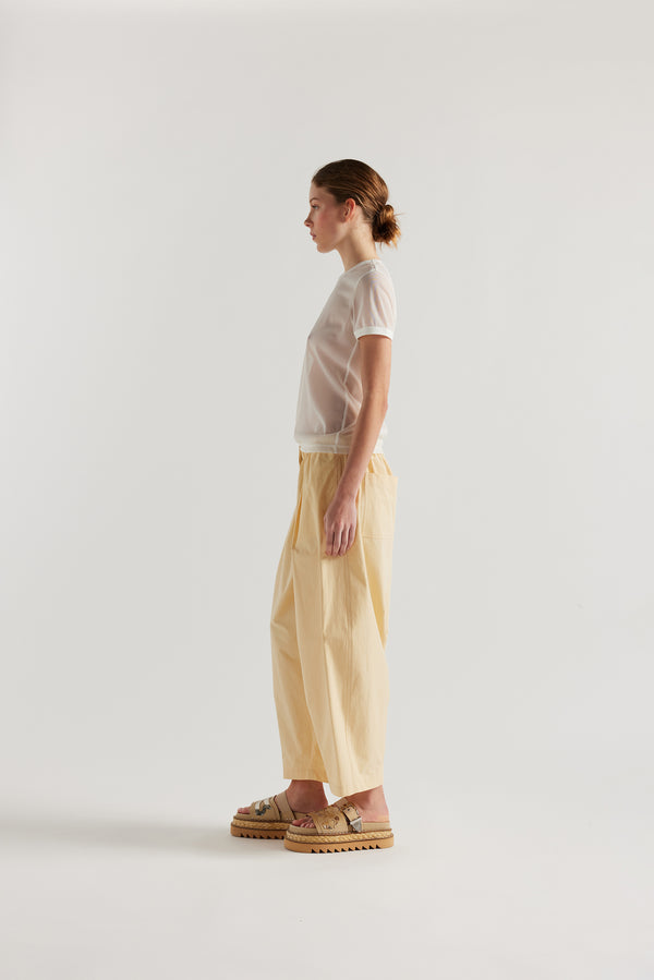 side view on female model of the slim-fit sheer knit tee with ringer neckline in White. 