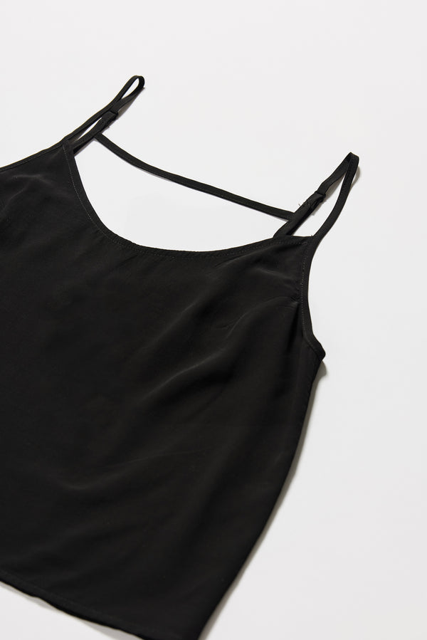 Flat detail view of black Viscose rayon Evolve Top with adjustable straps and fluid drape