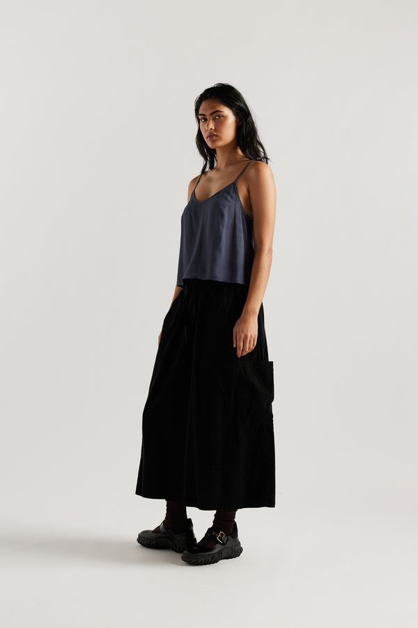 Front view of model in indigo blue Viscose rayon Evolve Top with adjustable straps and fluid drape