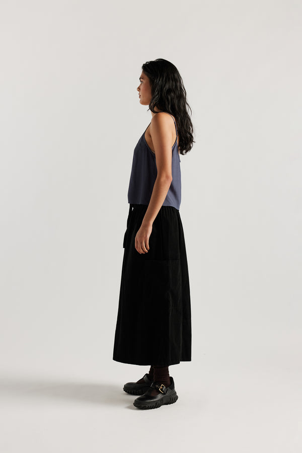 Side view of model in indigo blue Viscose rayon Evolve Top with adjustable straps and fluid drape