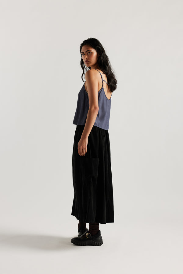 Back view of model in indigo blue Viscose rayon Evolve Top with adjustable straps and fluid drape