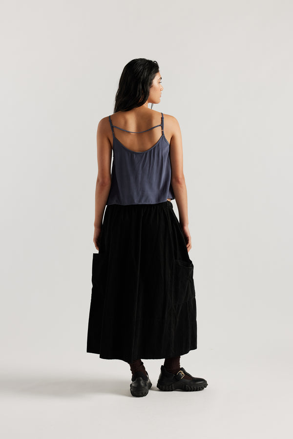 Back view of model in indigo blue Viscose rayon Evolve Top with adjustable straps and fluid drape