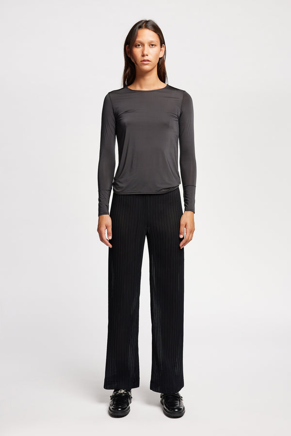 Front view of model in Jet Black Expansion long-sleeve fitted top in recycled poly with slim silhouette and classic crew neckline
