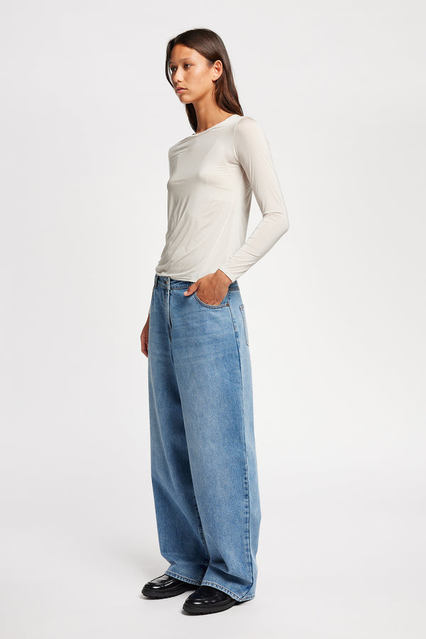 Front view of model in Off white Expansion long-sleeve fitted top in recycled poly with slim silhouette and classic crew neckline