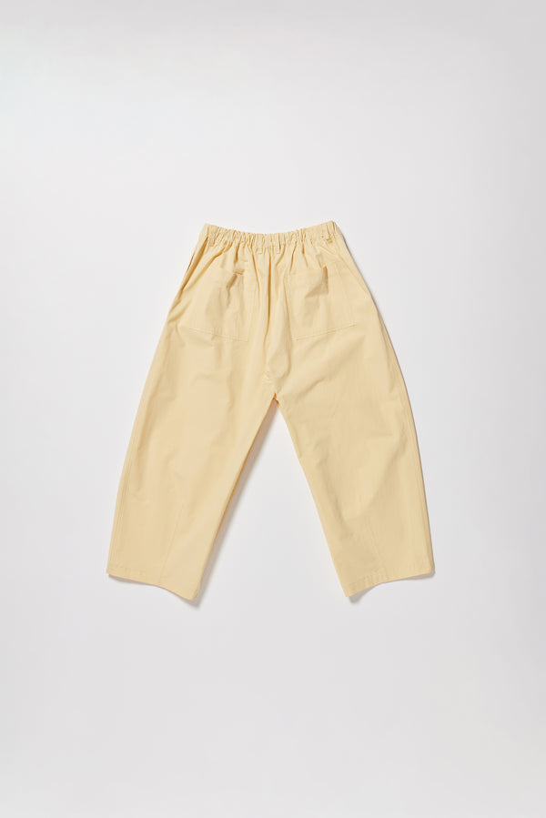 Flat back of the Factor Pleat Pant Buttermilk yellow. A relaxed silhouette defined by an encased elastic waistband. 