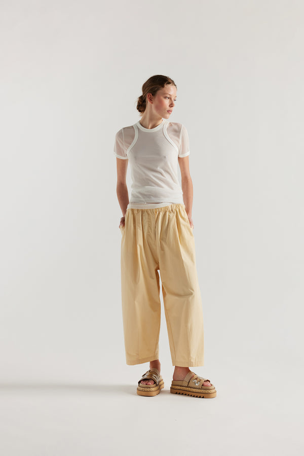 Front view of the model in the Factor Pleat Pant Buttermilk yellow. A relaxed silhouette defined by an encased elastic waistband. 