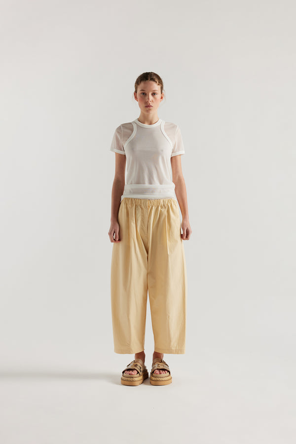 Front view of the model in the Factor Pleat Pant Buttermilk yellow. A relaxed silhouette defined by an encased elastic waistband. 
