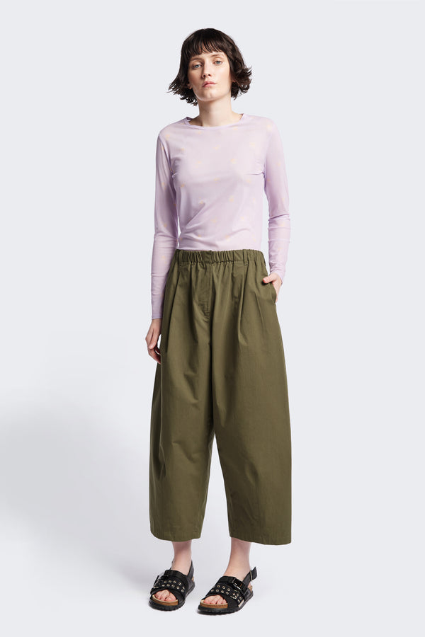 Front view of the model in the Factor Pleat Pant Olive Green. A relaxed silhouette defined by an encased elastic waistband. 
