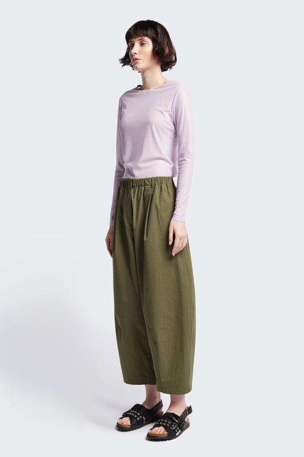 Front view of the model in the Factor Pleat Pant Olive Green. A relaxed silhouette defined by an encased elastic waistband. 
