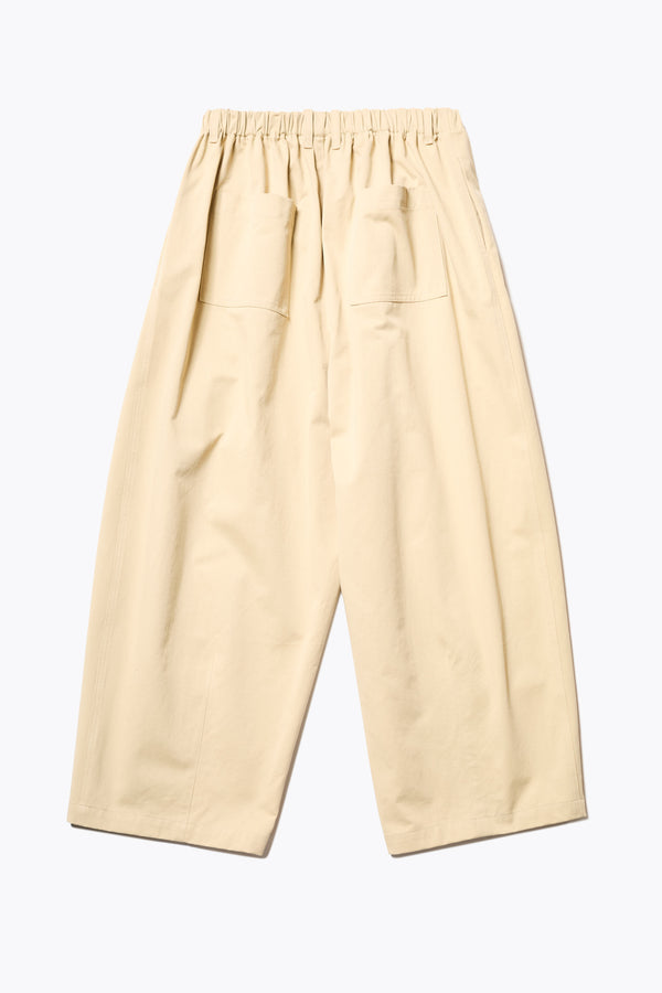 Back of The Factor Pleat Pant in Sand Yellow. A relaxed-fit pants with an encased elastic waistband, darted hem detail, side entry pockets, and back patch pockets. Comfortable and perfect for summer. Available in 6 sizes. 