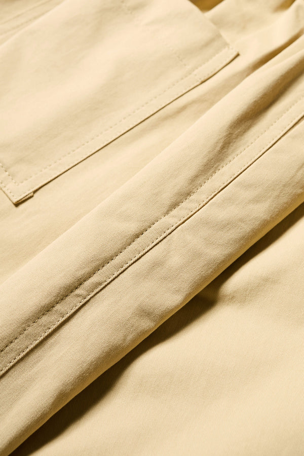 Close up fabric view of the Factor Pleat Pant in Sand Yellow. A relaxed-fit pants with an encased elastic waistband, darted hem detail, side entry pockets, and back patch pockets. Comfortable and perfect for summer. Available in 6 sizes. 