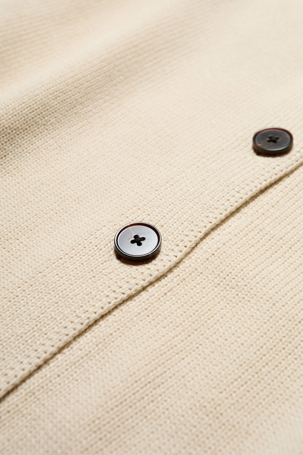 Close up fabric shot of the Flow Cardigan in Ecru Beige , relaxed boxy cardigan in soft cotton yarn with a crew neckline, button closure, and exaggerated dropped shoulders. Available in 5 sizes. 