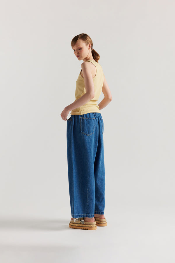 Back of Model wearing slim-fit Japanese ribbed cotton racer-back tank in Pale Yellow. 