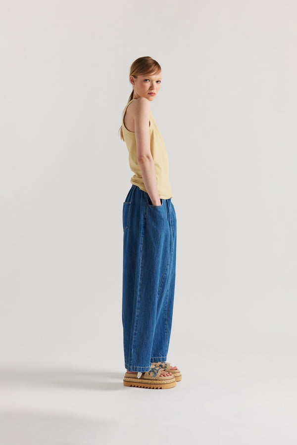 Side of Model wearing slim-fit Japanese ribbed cotton racer-back tank in Pale Yellow. 