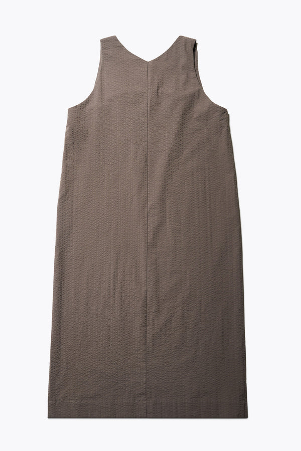 Back of the Long-length Forces Pinafore Dress in brown Kloke designed soft seersucker premium cotton. Relaxed fit with a deep rounded neckline, front patch pockets, and a front split for ease of movement. Available in 5 sizes. 