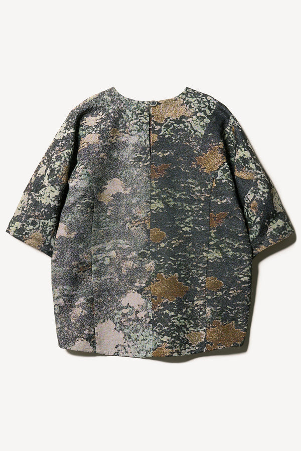 Flat back of the forge top in green print featuring a unique woven jacquard fabric with real tree camouflage pattern, sculptured panelled sleeves, and a contemporary fit