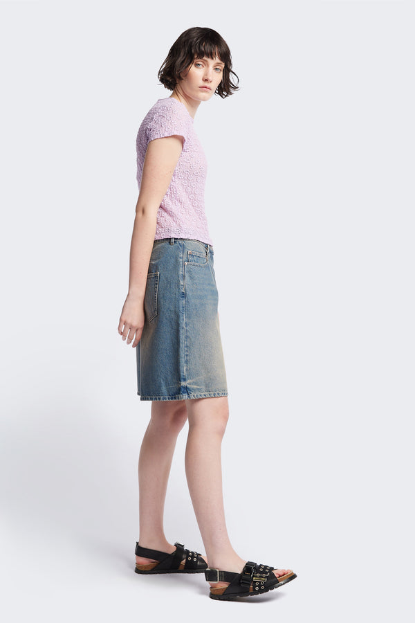 Side view of The Fuego Longline denim shorts in a blue fade with a subtle pink tint, featuring darted waist details and a relaxed wide-leg design. Available in 6 sizes. 