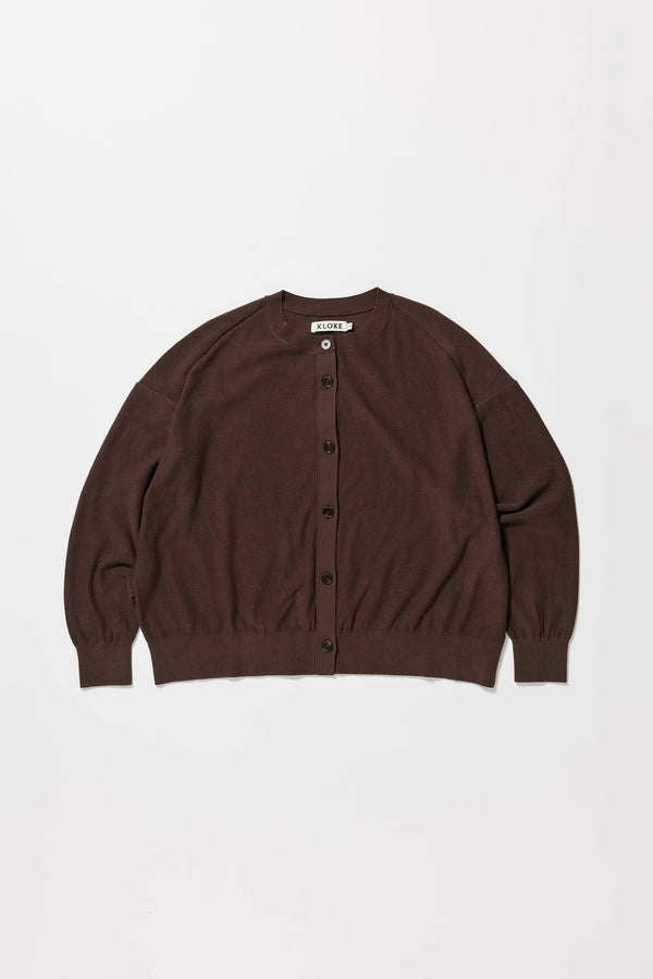 Flat front of the brown cotton ribbed sweater with button closure and dropped shoulders.