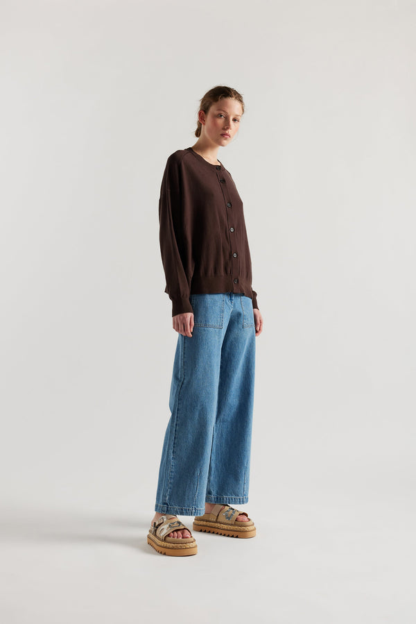 Front view of model in the brown cotton ribbed sweater with button closure and dropped shoulders.