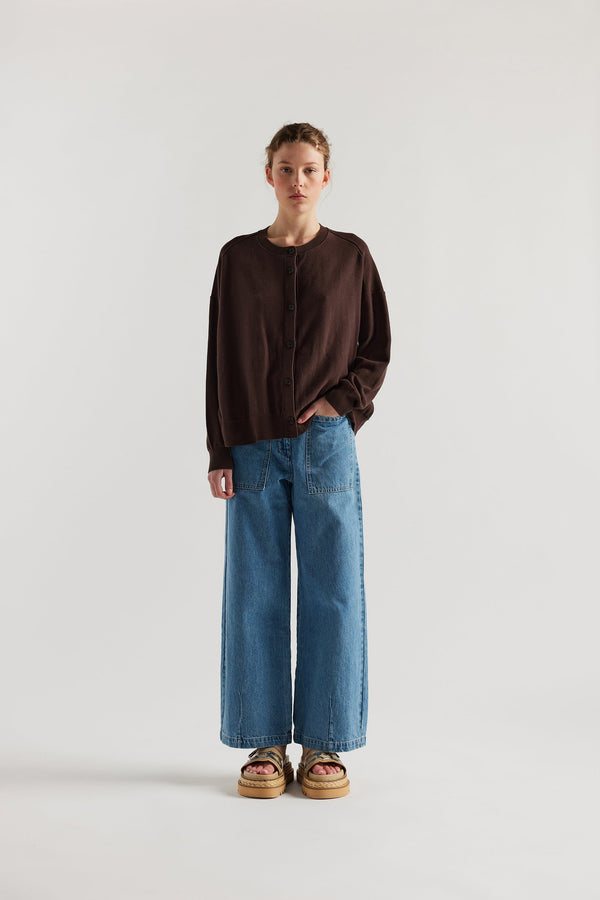 Front view of model in the brown cotton ribbed sweater with button closure and dropped shoulders.