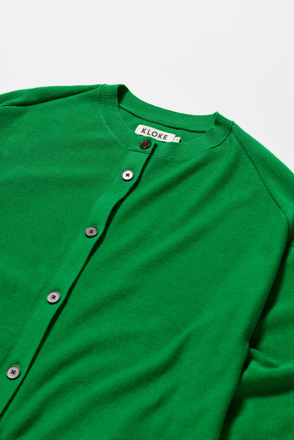 Detail shot of raw-edge seam on soft cotton sweater in vivid green.