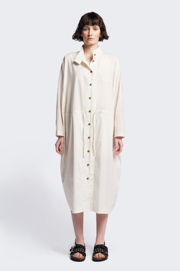 Front of the ecru Iberia Dress, an oversized day dress with loose sleeves and underarm gusset detail, featuring adjustable ties at the front and back for a cinched waist or relaxed fit.