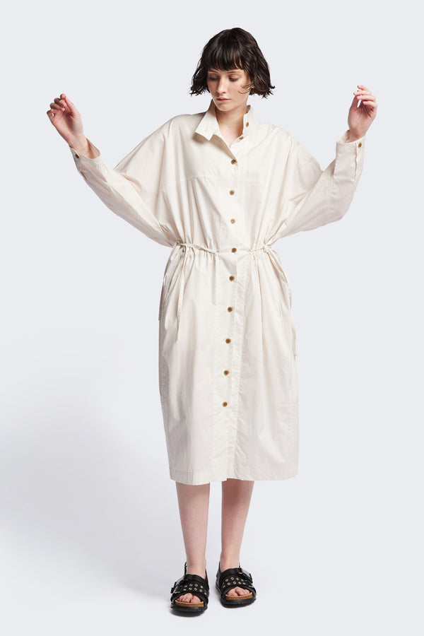 Front of the ecru Iberia Dress, an oversized day dress with loose sleeves and underarm gusset detail, featuring adjustable ties at the front and back for a cinched waist or relaxed fit.