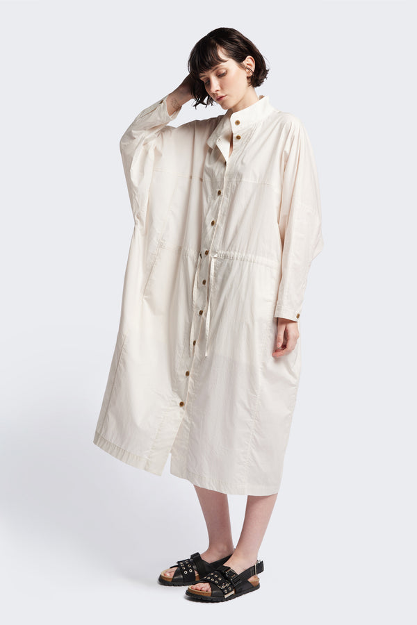 Front of the ecru Iberia Dress, an oversized day dress with loose sleeves and underarm gusset detail, featuring adjustable ties at the front and back for a cinched waist or relaxed fit.