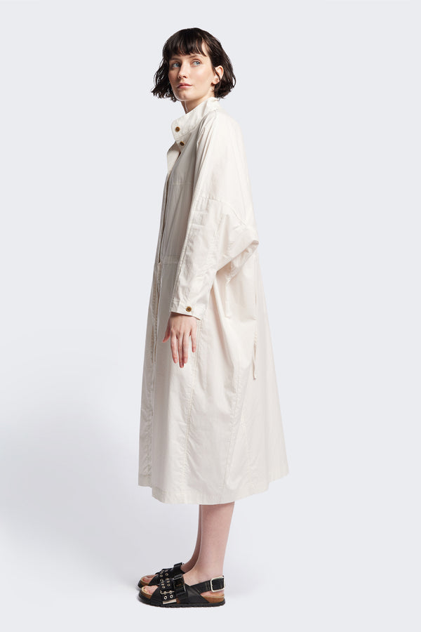 Side of the ecru Iberia Dress, an oversized day dress with loose sleeves and underarm gusset detail, featuring adjustable ties at the front and back for a cinched waist or relaxed fit.