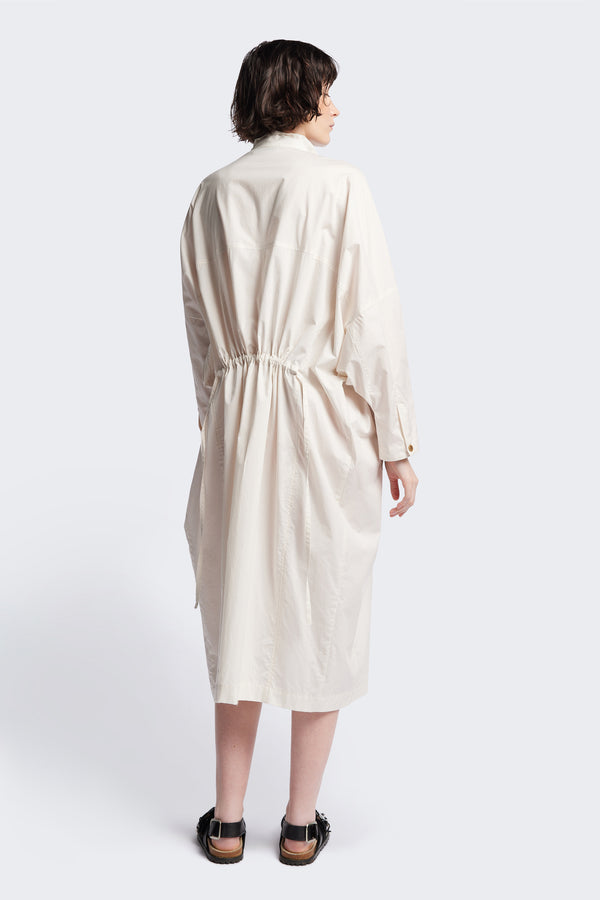 Back of the ecru Iberia Dress, an oversized day dress with loose sleeves and underarm gusset detail, featuring adjustable ties at the front and back for a cinched waist or relaxed fit.