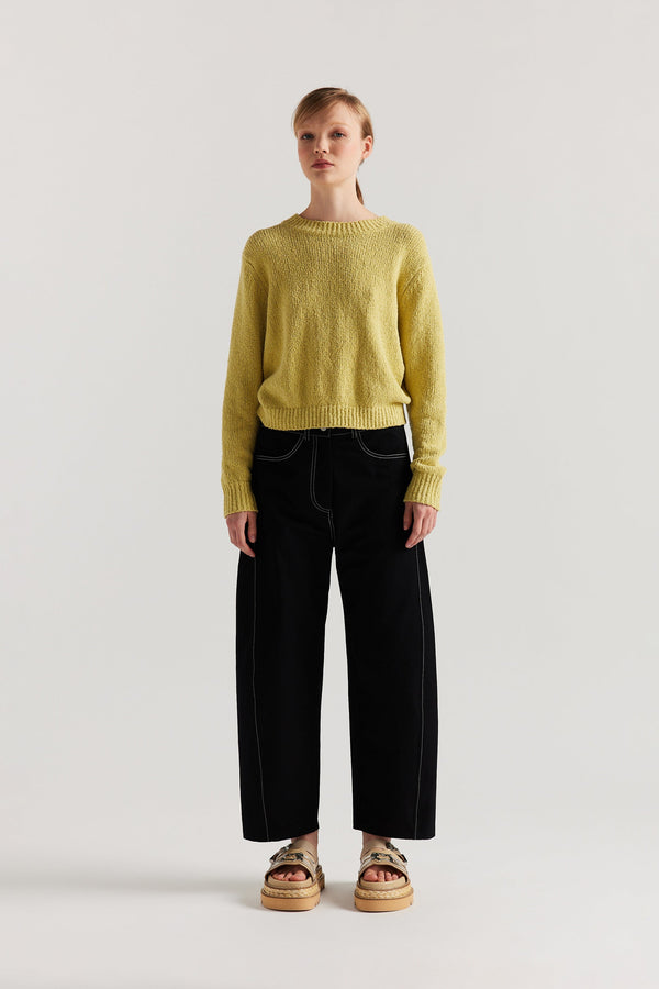 Front of Model wearing tailored cotton pants in black with contrast-stitch front seam panelling.