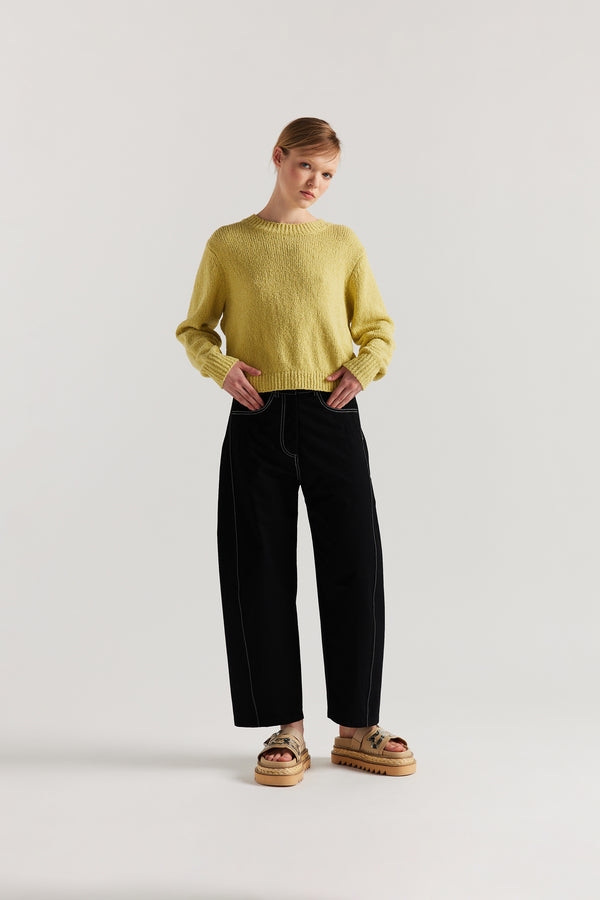 Front of Model wearing tailored cotton pants in black with contrast-stitch front seam panelling.