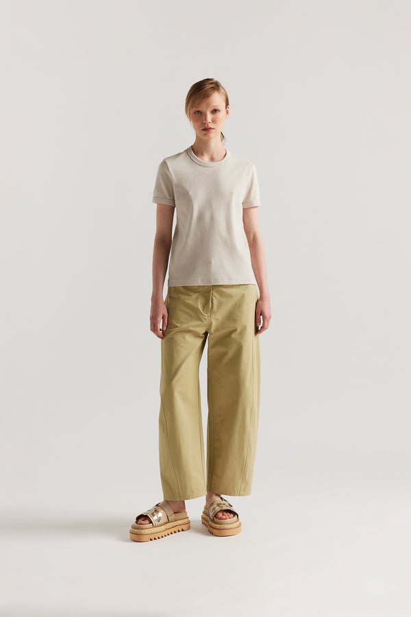 Front of Model wearing tailored cotton pants in sand with contrast-stitch front seam panelling.