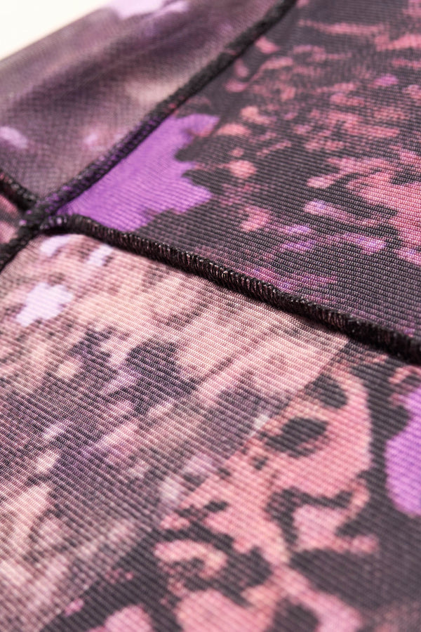 Close up fabric detail shot of the Inlet Top in Real Tree purple print, featuring a slim fit, semi-sheer mesh fabric, and black baby lock stitching.