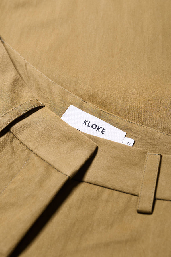 Close up of Fabric for the Interim Pant in Olive Brown, Tailored wide-leg in premium cotton with double-front pleats, side slant pockets, jet back pockets, and a hook-and-bar closure. Available in 6 sizes.