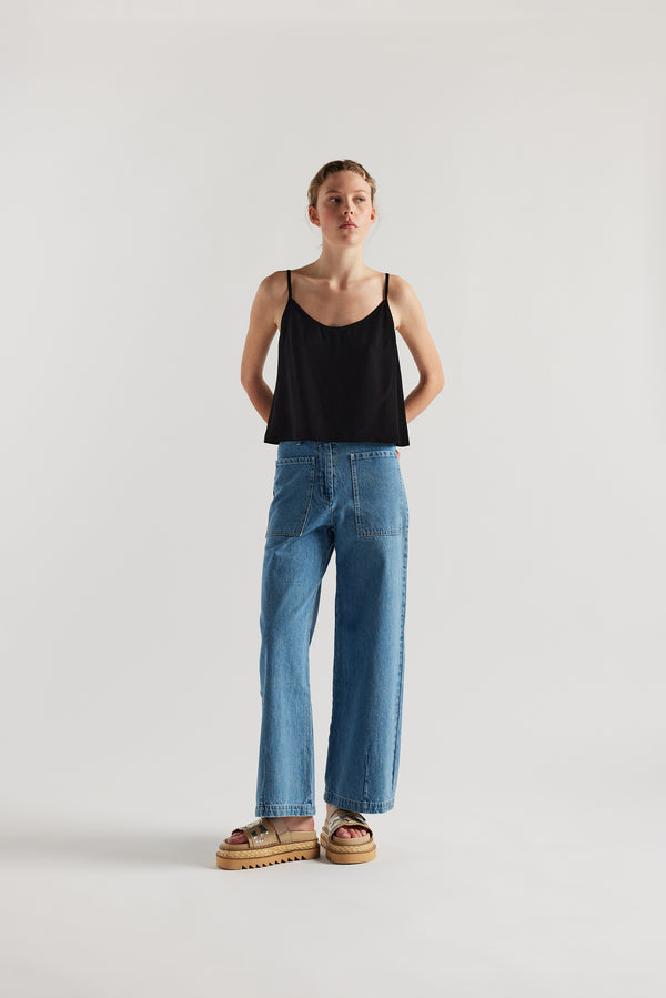 Front of female model in the mid blue straight wide-leg denim jeans with a higher-rise waist, patch pockets, and back yoke detail, shown from the front.