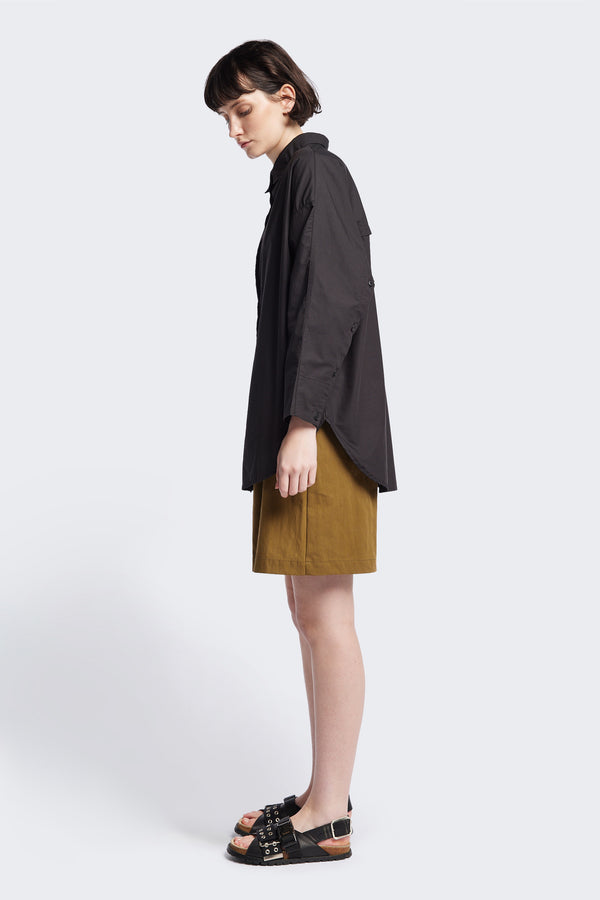 Side of Kestrel Shirt Black – relaxed long sleeve shirt with back button placket and scoop hemline, worn by model. Available in XXS, XS, S, M, L 