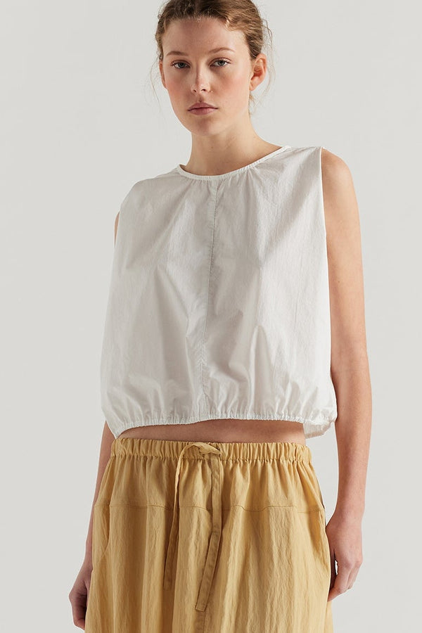 Front view of female model in the White Lambent Top front view showing round neckline and centre-front seam detail

