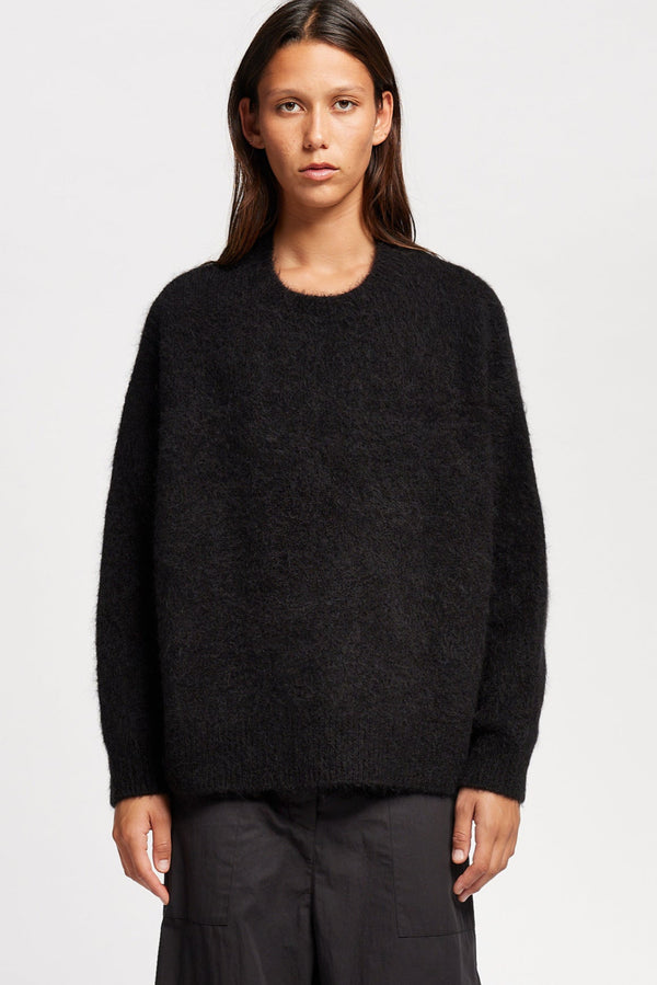 Front view of Model wearing alpaca blend Laurel Crew Neck Knit Sweater in black