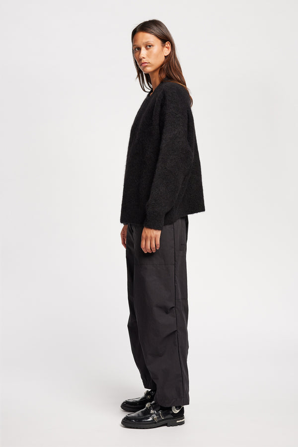 side view of Model wearing alpaca blend Laurel Crew Neck Knit Sweater in black  