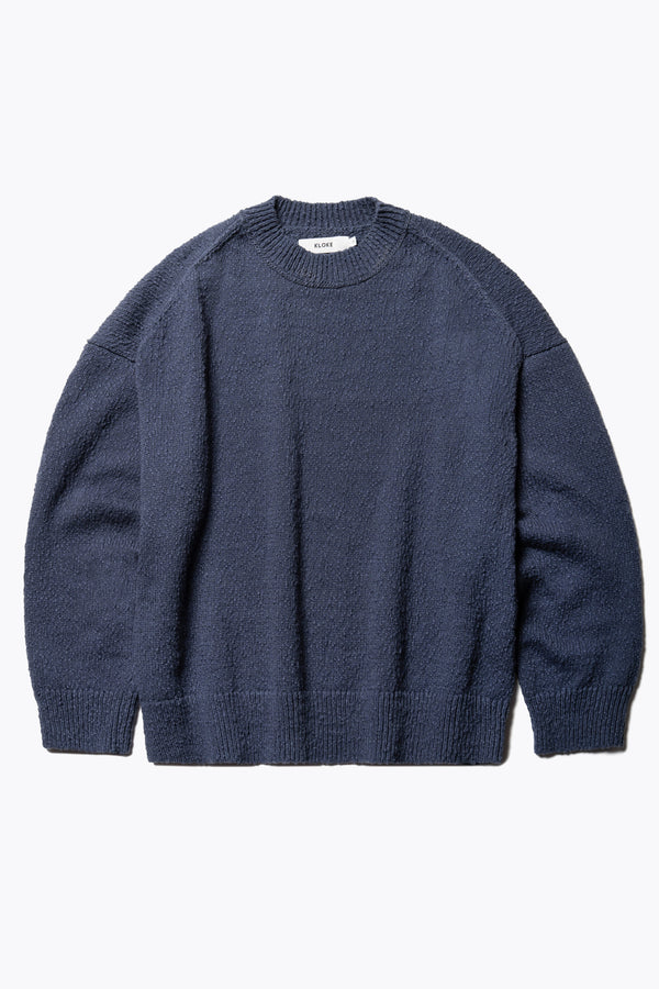 Flat Front of the Blue Leeway Sweater in a soft chunky cotton knit, featuring an oversized relaxed fit, raglan sleeves, and ribbed hem and cuffs.