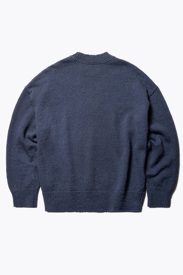 Flat Back of the Blue Leeway Sweater in a soft chunky cotton knit, featuring an oversized relaxed fit, raglan sleeves, and ribbed hem and cuffs.