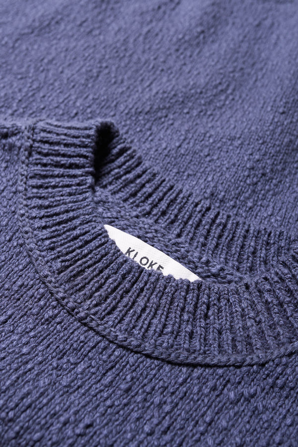 Close up details of the Blue Leeway Sweater in a soft chunky cotton knit, featuring an oversized relaxed fit, raglan sleeves, and ribbed hem and cuffs.