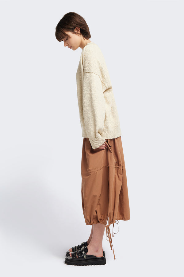 Side of the Ecru Leeway Sweater in a soft chunky cotton knit, featuring an oversized relaxed fit, raglan sleeves, and ribbed hem and cuffs.