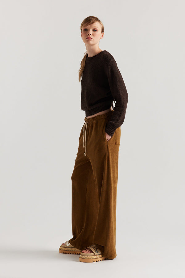 Side of model in the brown Levity Tie Top with open back and adjustable tubular ties in soft cotton–nylon knit