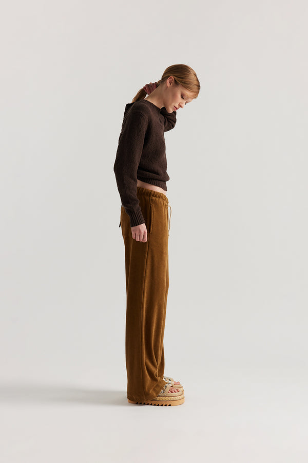 Side of model in the brown Levity Tie Top with open back and adjustable tubular ties in soft cotton–nylon knit