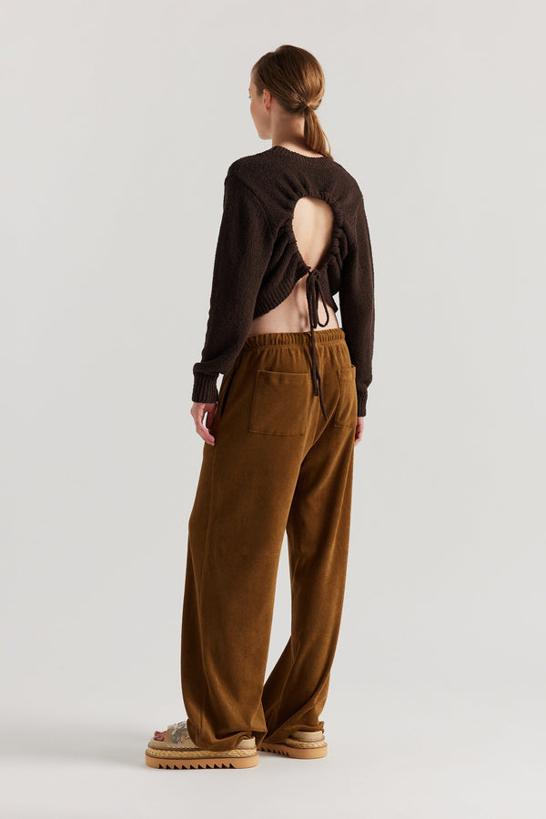 Back of model in the brown Levity Tie Top with open back and adjustable tubular ties in soft cotton–nylon knit