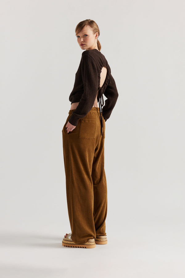 Back of model in the brown Levity Tie Top with open back and adjustable tubular ties in soft cotton–nylon knit