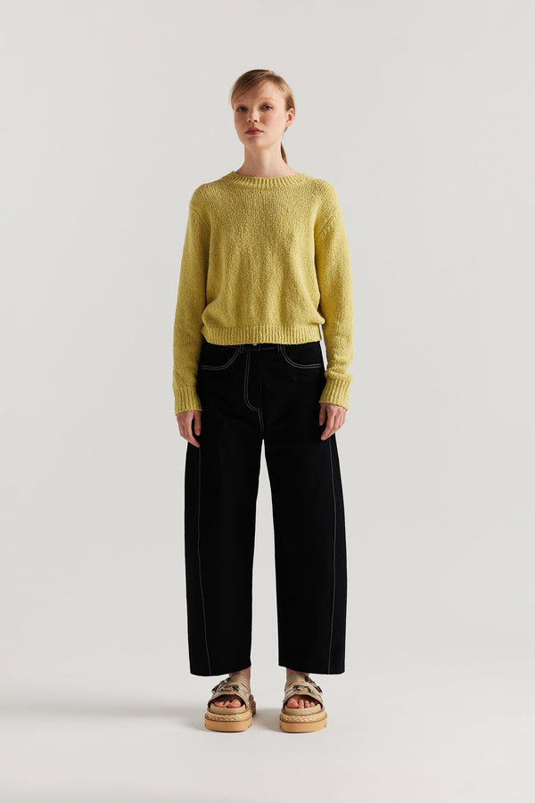 Front of model in the yellow Levity Tie Top with open back and adjustable tubular ties in soft cotton–nylon knit