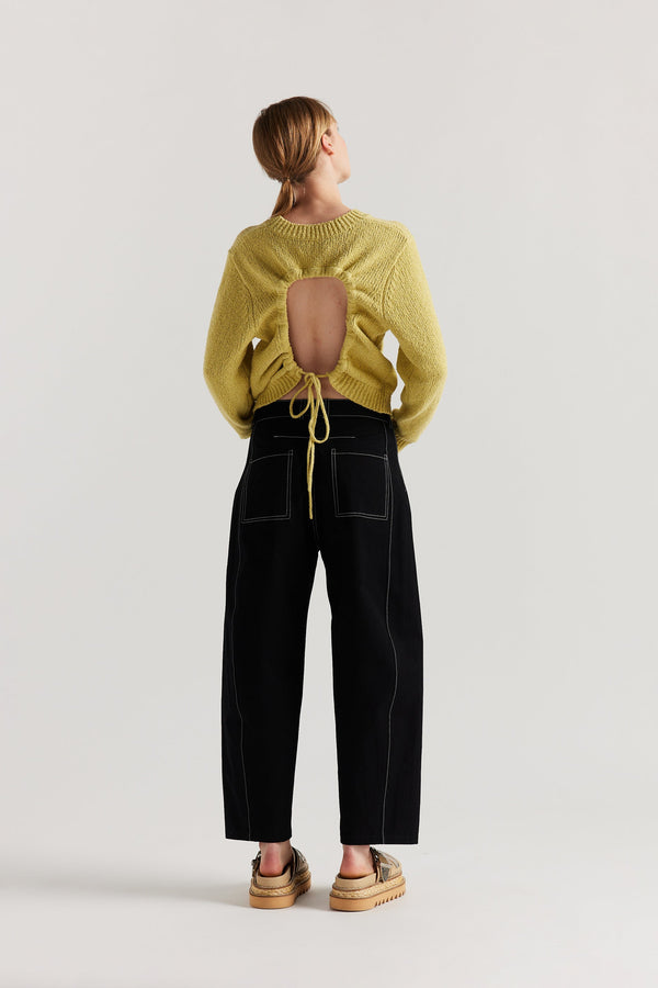 Back of model in the yellow Levity Tie Top with open back and adjustable tubular ties in soft cotton–nylon knit